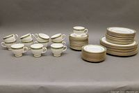 Full set overview showing teacups at left and stacked plates and saucers at right