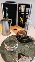 Bar set items displayed inside carrying case and on marble board
