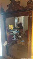 Full view of large wood framed mirror showing entire frame and reflective glass.