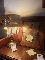 Photo showing the brass tone lamp and the framed wall art side-by-side on a wooden surface under warm lighting.