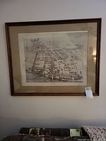 Framed map of Riverton, NJ in 1890 hanging on wall, showing the full map within a wooden frame with beige mat.