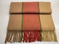 Full view of the folded cashmere scarf showing pale coffee color with tangerine stripe and avocado green borders, with fringed end visible.