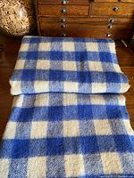 Folded blanket showing the blue and cream checkered pattern and texture.