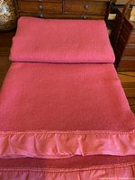 Folded hot pink Kenwood blanket showing satin trim.