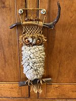 Full view of the entire vintage macrame owl hanging on driftwood showing the overall design and materials used