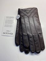 Full view of men's dark chocolate leather glove, showing front design and Isotoner tag with size M.