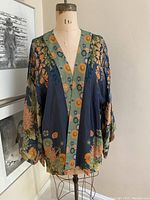 Front view of the POWDER floral kimono on dress form, showing full garment with floral design and neckline trim.