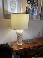 Full view of assembled lamp with shade on wooden table and artwork background