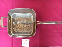 Top view of the square deep fry basket with stainless steel handles and perforated bottom fitting inside the pot