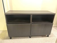 Front view of IKEA Besta cabinet showing 2 open shelves on top and 2 doors below.