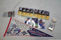 Photo showing the entire collection of Toronto Blue Jays baseball memorabilia, cards, signed pennant, signed ball, signed photo, and memorabilia box on a tabletop surface.