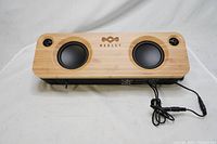 Front view of House of Marley Get Together speaker showing bamboo front panel with 2 black speaker drivers and power cable attached