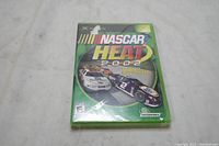 Front view of NASCAR Heat 2002 Xbox game in green case with shrink wrap.