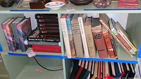 Shelf with various books including Harry Potter, golf and dictionary volumes showing some wear and damage