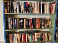Bookshelves filled with hardcover books on American presidents and first ladies. Three shelves shown filled with books.
