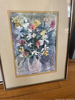 Framed watercolor floral painting signed by Penny Kinsey with various flowers in soft color palette, matted with gold trim