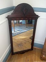 Full view of the rectangular mahogany framed wall mirror showing the reflective surface and wood frame with carved details.