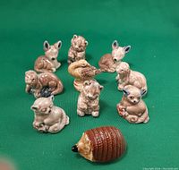 10 Wade Red Rose Tea animal figurines arranged on green background, visible details of various small animals including hedgehog, duck, deer, bear, dog.