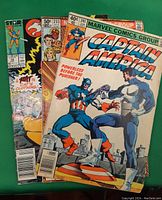 Three comic books stacked showing front covers featuring Captain America, Fantastic Four, and a Star Comics issue featuring Thundercats.