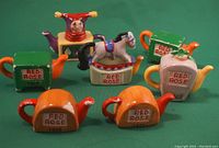 Group photo showing all seven miniature ceramic teapots with Red Rose labeling in various colors and designs.