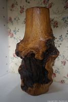 Front view of the burled wood branch vase showing polished wood with natural knots and medium tone finish.