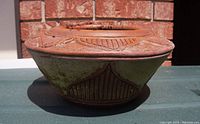 Side view of the oval terracotta pottery planter showing detailed textured patterns around the upper rim and lower base area.