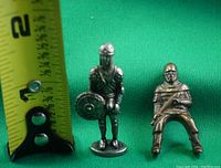 Miniature metal soldiers shown with measuring tape for size, approx. 1.25 inches tall.