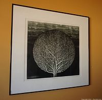 Framed print showing the entire artwork on a wall with visible chip on bottom left glass corner.