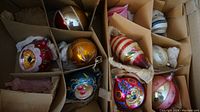 View of all 10 vintage mercury glass Christmas ornaments arranged in cardboard packaging.