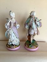Front view of both porcelain figurines side by side