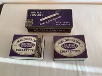 Top view of three vintage British Consols cigarette tins in purple and cream colors showing logos and design details.