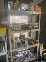 Wide view of shelves holding various automotive maintenance items including oil filters in boxes, sprays and other accessories.