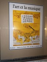 Photo of framed art print 'l'art et la musique' with French text, violin illustration, and music notes