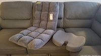 Velago Clam adjustable folding plush gaming chair and orthopedic lumbar support cushion displayed on couch showing front view with tags.