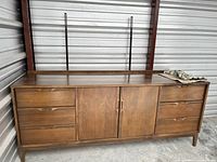 Full front view of dresser on concrete floor under metal walls.
