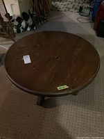 Top view of the round dark stained pine coffee table showing surface marks and scratches.