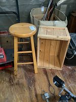 Full view of the solid wood stool and wooden crate on a wooden floor with background items
