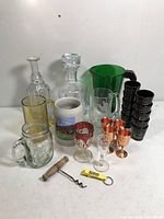 Overview of all barware items including glass decanters, pitchers, shot glasses, cordial glasses, mugs, and corkscrew.