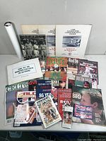 Overview of the ephemera collection spread out showing programs, commemorative folders, magazines, and posters mainly from Boston sports teams.