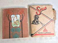 Two vintage scrapbooks side by side; one with an illustrated cover and the other titled Scrap Book of Clippings with a dog illustration