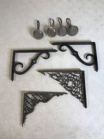 Four glass knobs and three metal brackets on a white surface showing matching set and condition.