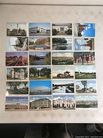 Full view of 24 assorted vintage Manchester NH postcards laid out in rows, showing various city landmarks, buildings, bridges, waterways, and public spaces.