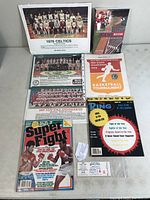 Overview of the vintage sports memorabilia lot including team photos, booklets, tournament programs, magazines, and ticket stub.