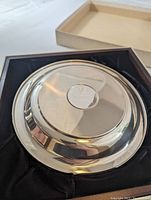 Underside of dish showing hallmark and polished finish, tray removed from box.