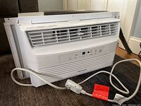 Front view of white Frigidaire window air conditioner unit with power cord visible.