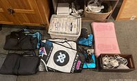 Overview of console, controllers, game cases, balance board, mats, joystick, and cords on floor