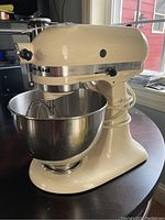 KitchenAid Classic model K45SS cream-colored stand mixer showing side profile and stainless steel bowl on table.