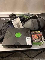 Top view of entire lot showing Xbox console, controllers, carry bag, game cases, and massage belt.