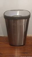 Front view of the 50 litre garbage can with stainless steel body and black plastic lid and base.