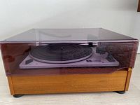 Side view showing the turntable with teak wood cabinet and tinted plastic dust cover in place.